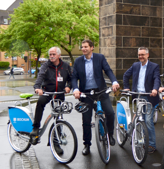 Bochum: Die Rundfahrt der AGFS-Delegation durch Bochum endete an der Christus-Kirche. Im Bild (v.l.): der Landtagsabgeordnete Dieter Hilser als Leiter der fast 40-köpfigen Auswahlkommission, Oberbürgermeister Thomas Eiskirch und Stadtbaurat Markus Bradtke.