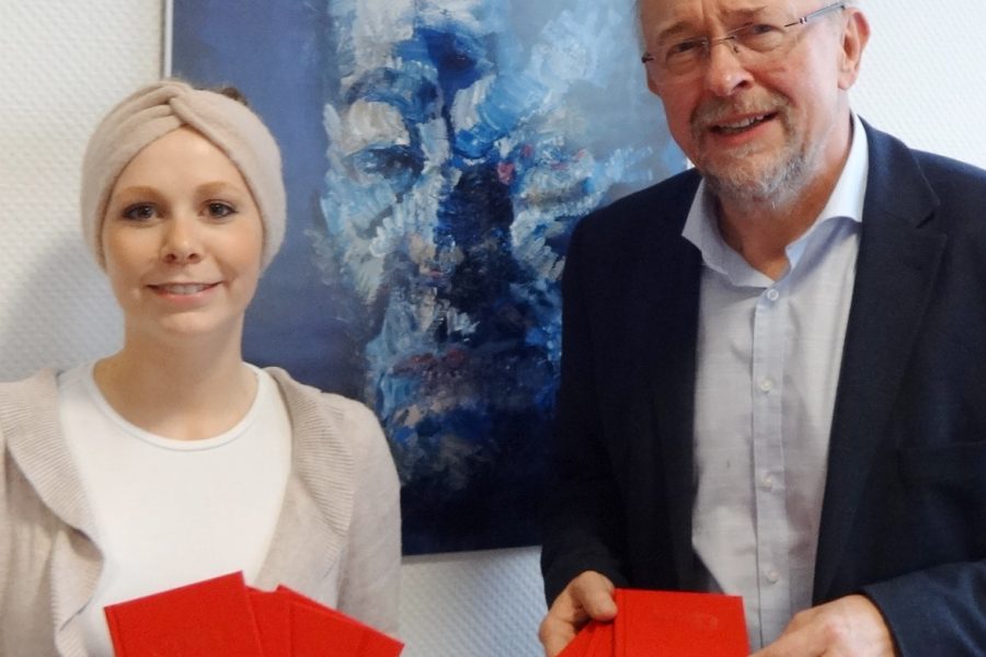 Lisa Methling, Mitarbeiterin im Büro der SPD Bochum, Axel Schäfer, SPD MdB, mit den Parteibüchern für einige der Neumitglieder