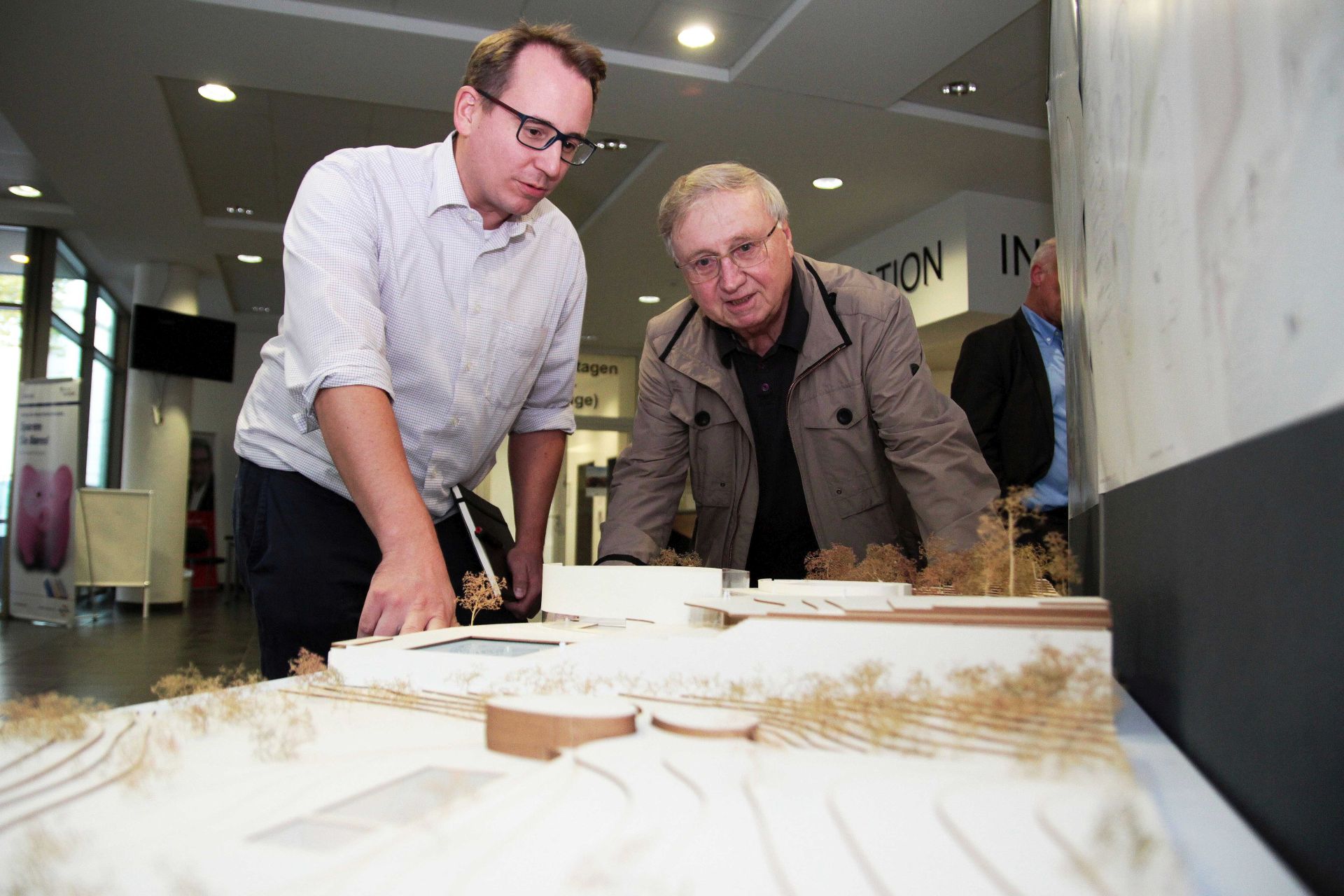 Die SPD-Ratsmitglieder Burkart Jentsch (li.) und Dieter Fleskes schauen sich die Entwürfe der Architektur-Studierenden zum Hallenfreibad Höntrop an.