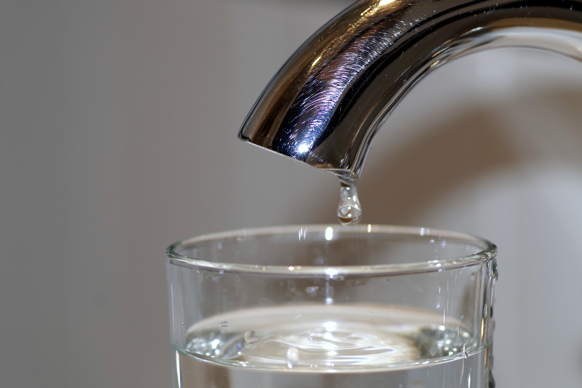 Ein Wasserhahn und ein Glas Wasser