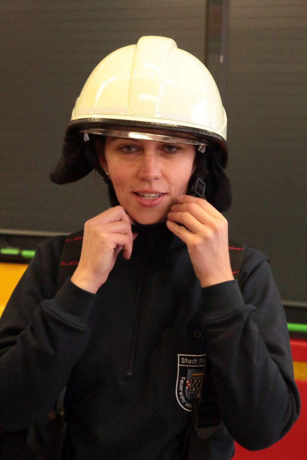 Deborah Steffens schnallt sich einen Feuerwehrhelm auf. Ohne geht im Einsatz nichts.